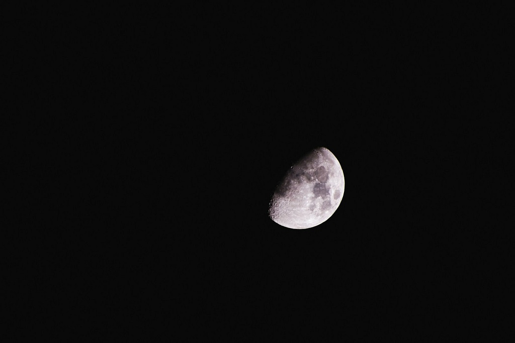 a waxing gibbous moon is seen in the dark sky