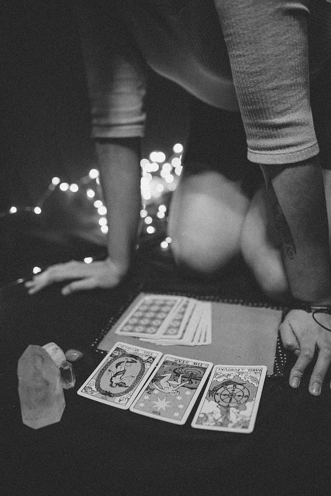 Tarot cards, crystals, and a journal laid out on a table, illustrating practices that support Enneagram self-awareness and emotional grounding.