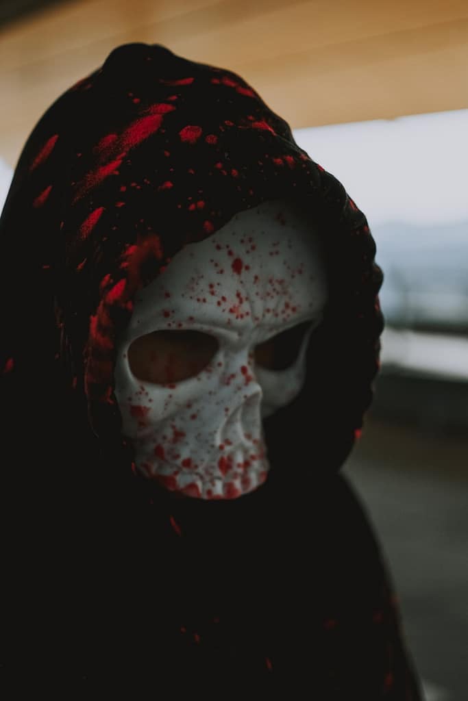 Person in a skull mask and dark hood representing fake tarot readers who use fear and manipulation, highlighting why this is harmful.
