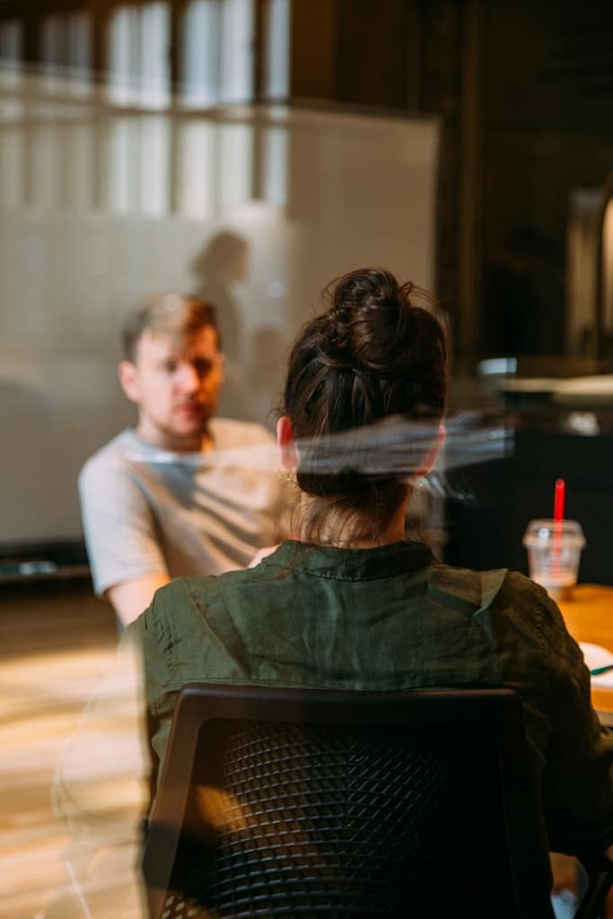 Two people in a therapy session, one listening attentively to the other, representing the supportive space therapy provides to help process emotions and overcome feeling emotionally drained.