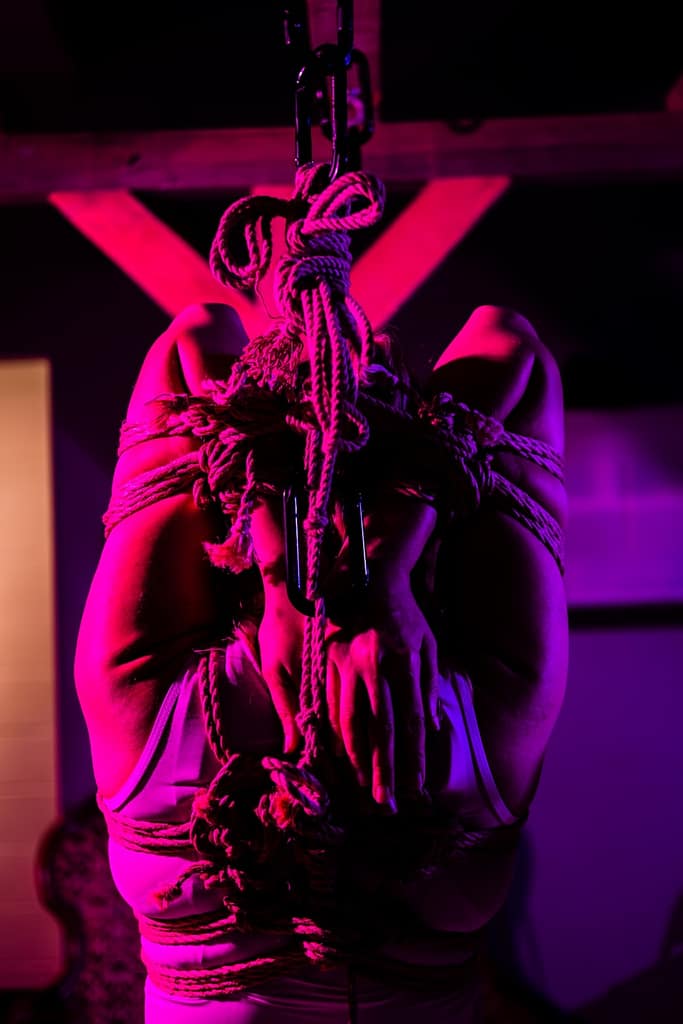 a woman hanging from a rope in a room