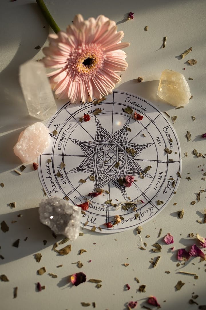 Top view of a mystical floral arrangement with the Wheel of the Year surrounded by petals and crystals, capturing natural beauty.