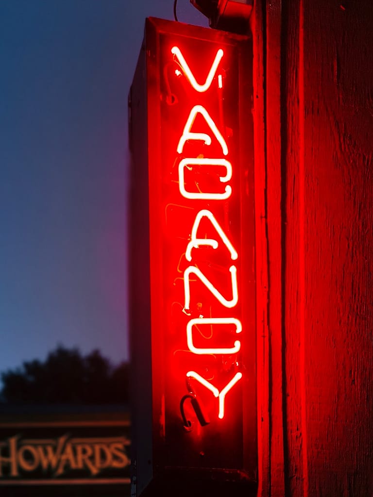 Red neon ‘Vacancy’ sign glowing at night, representing career uncertainty and the search for purpose — a symbol of finding direction through tarot.
