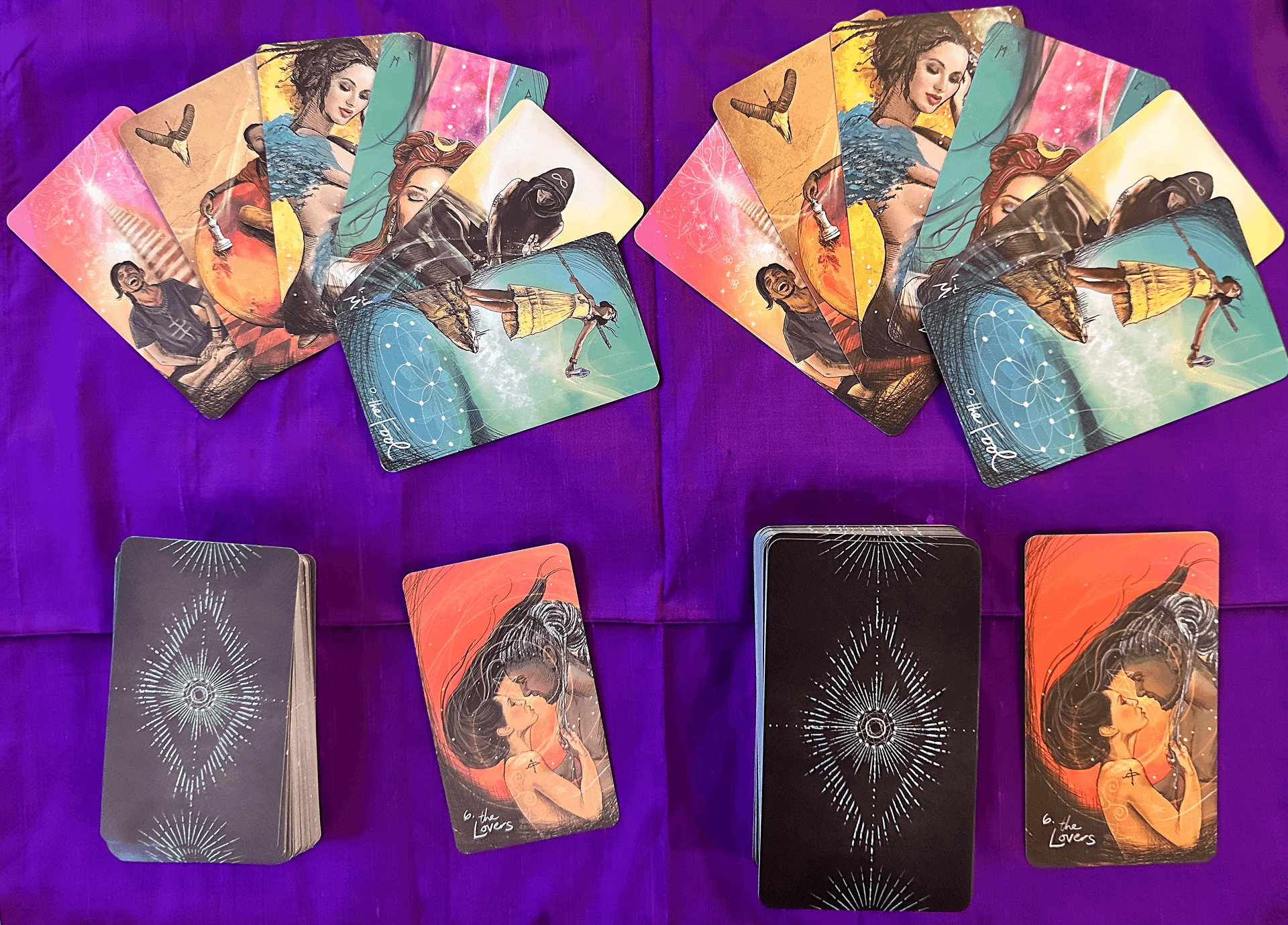 Two tarot decks side by side on a purple cloth. The left deck has muted colors and thinner cards, while the right deck has vibrant colors and thicker cards.