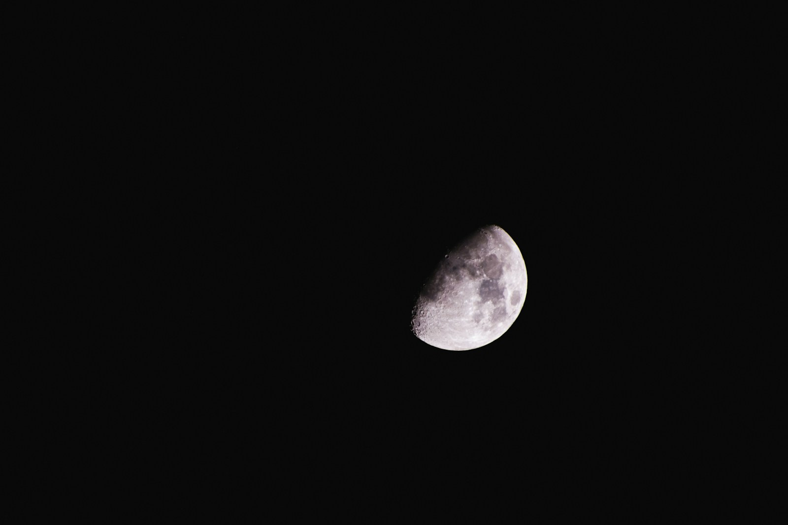 a waxing gibbous moon is seen in the dark sky