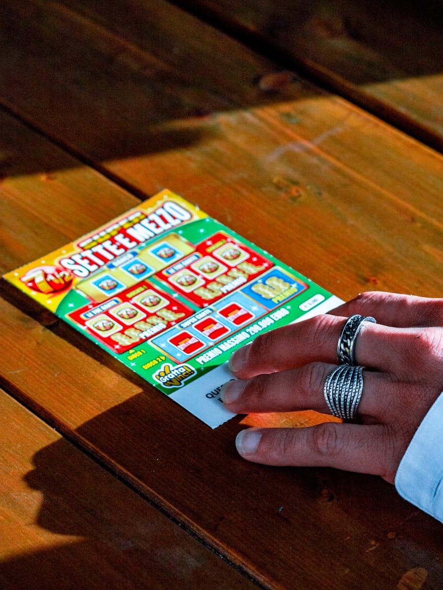 person in white long sleeve shirt holding lotto ticket