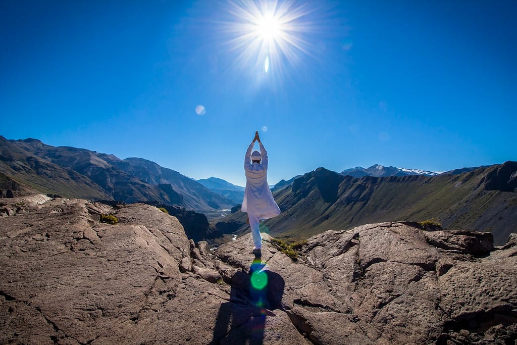 a person standing on top of a mountain with their arms in the air